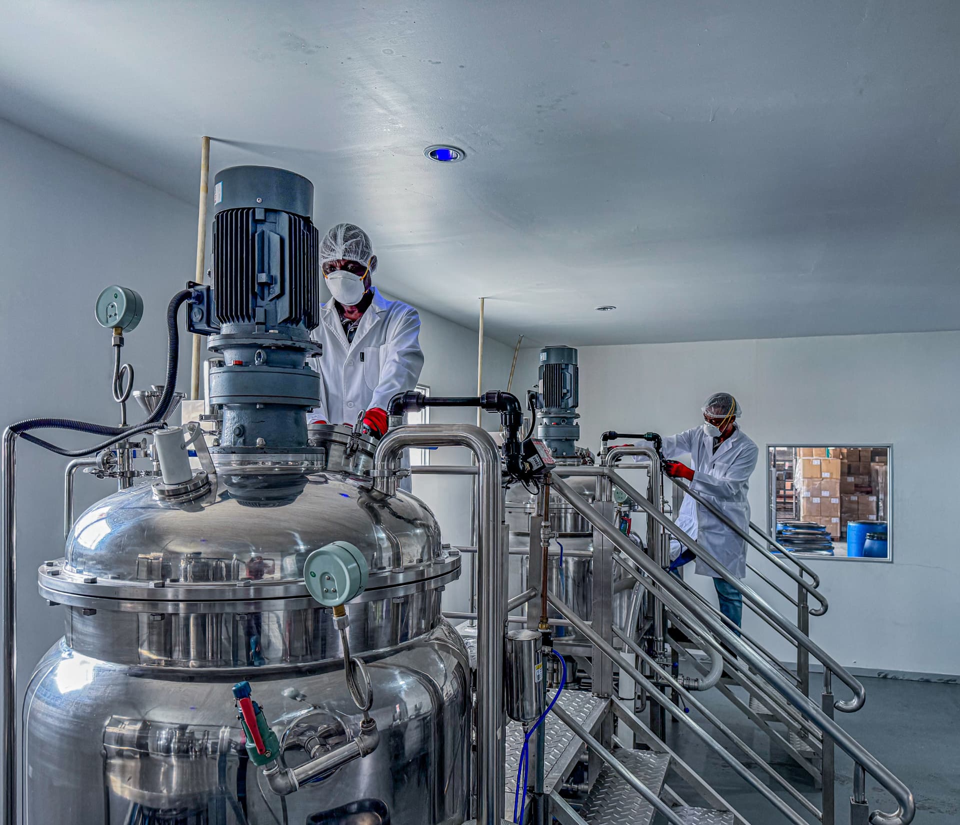 Technician operating a stainless steel mixing vessel